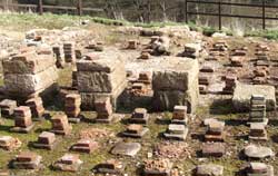 Pillars of brick, originally ten or 
        eleven slabs high, that once supported the floor in the hotroom of the 
        pre-Hadrianic baths. The tilery in which the soldiers made these has not 
        yet been located.